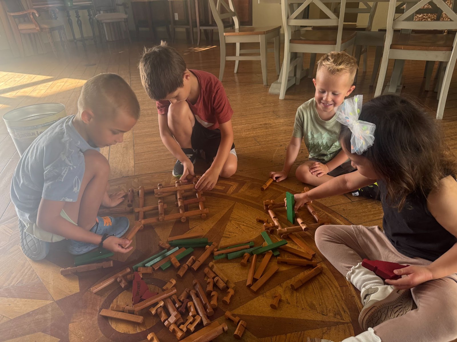 Students sitting on the floor while building story-inspired engineering structures.