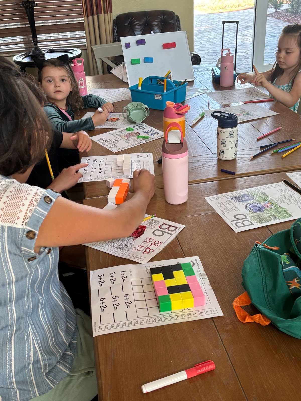 Students working on math and writing activities together around a table.