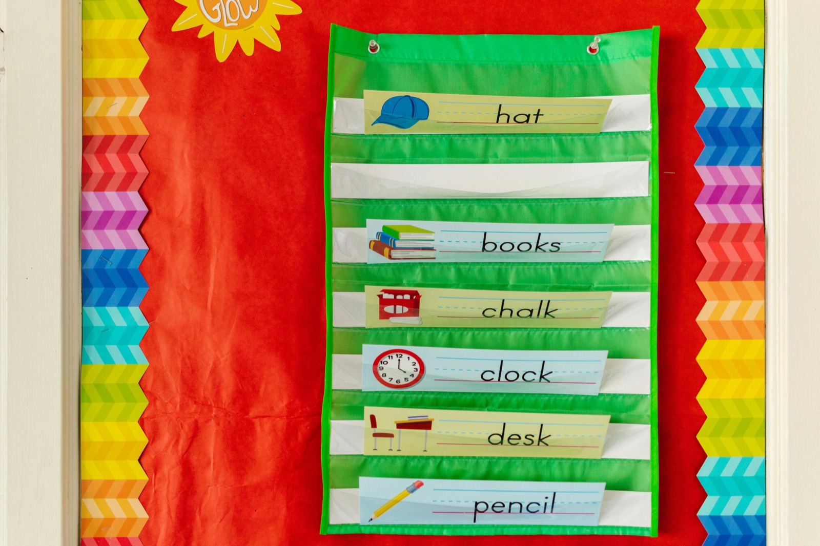 Colorful classroom teaching supplies and word cards arranged on a wall display.
